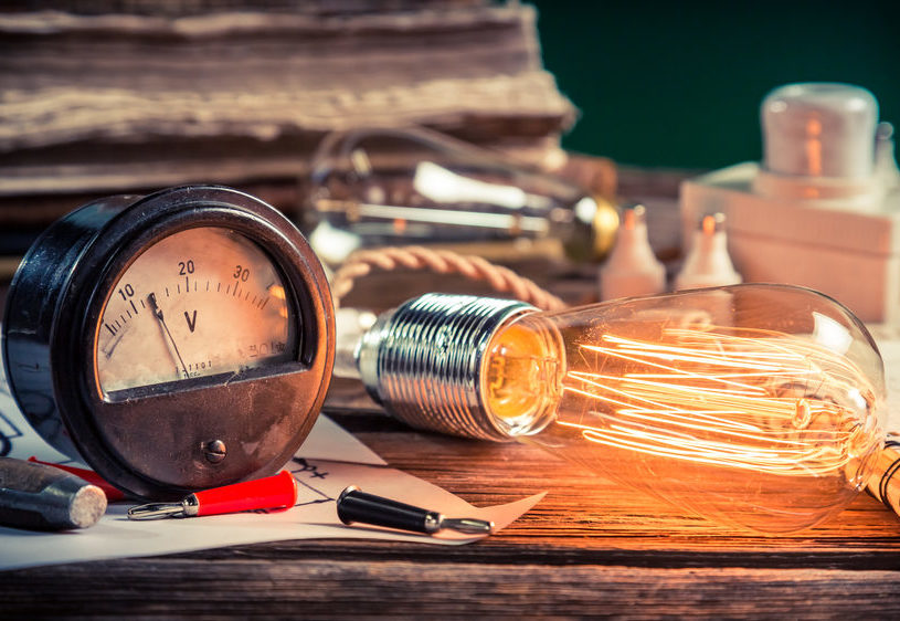 Edison bulb, voltmeter and electrical tools on desk