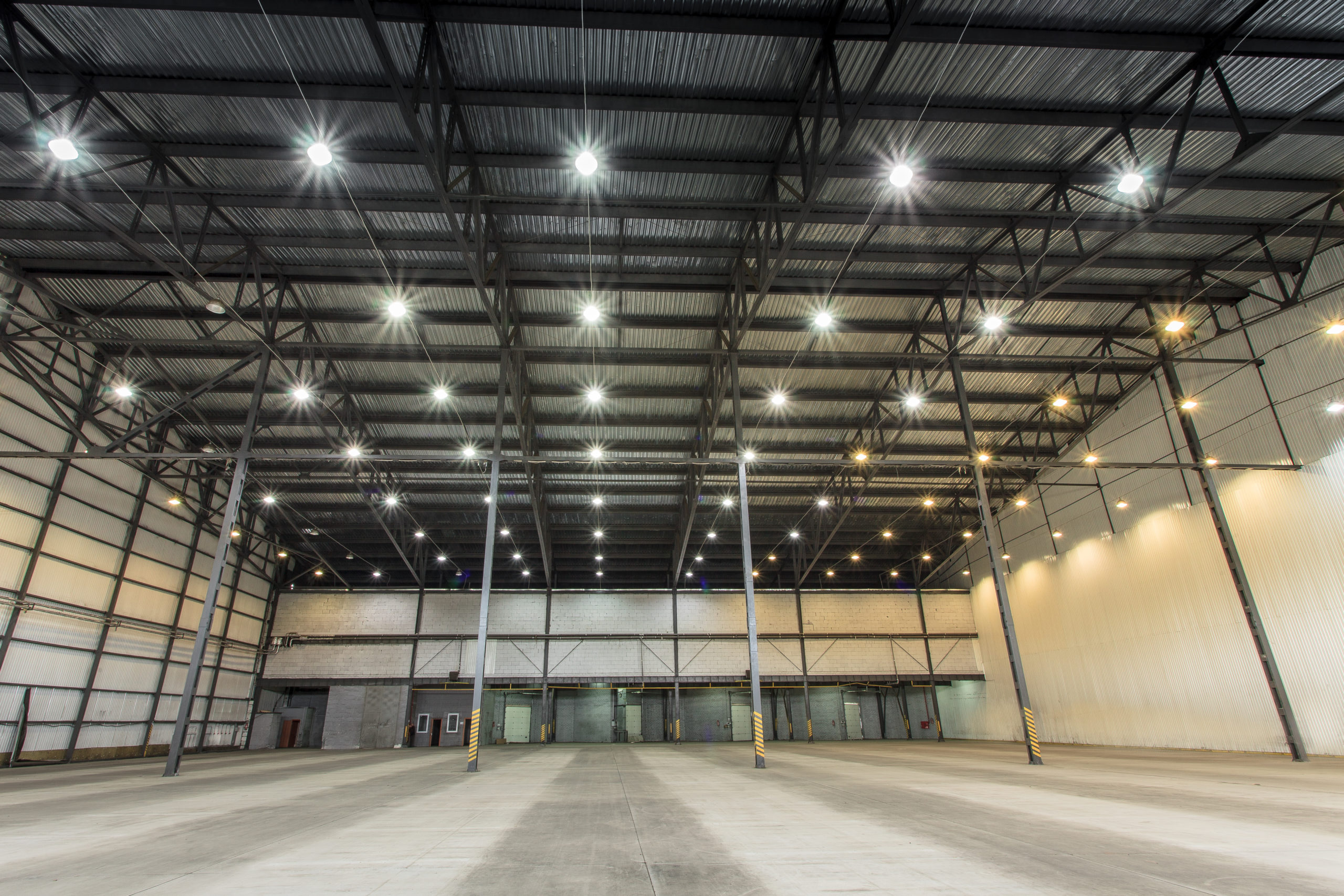 A large empty warehouse with many hanging lights on the ceiling